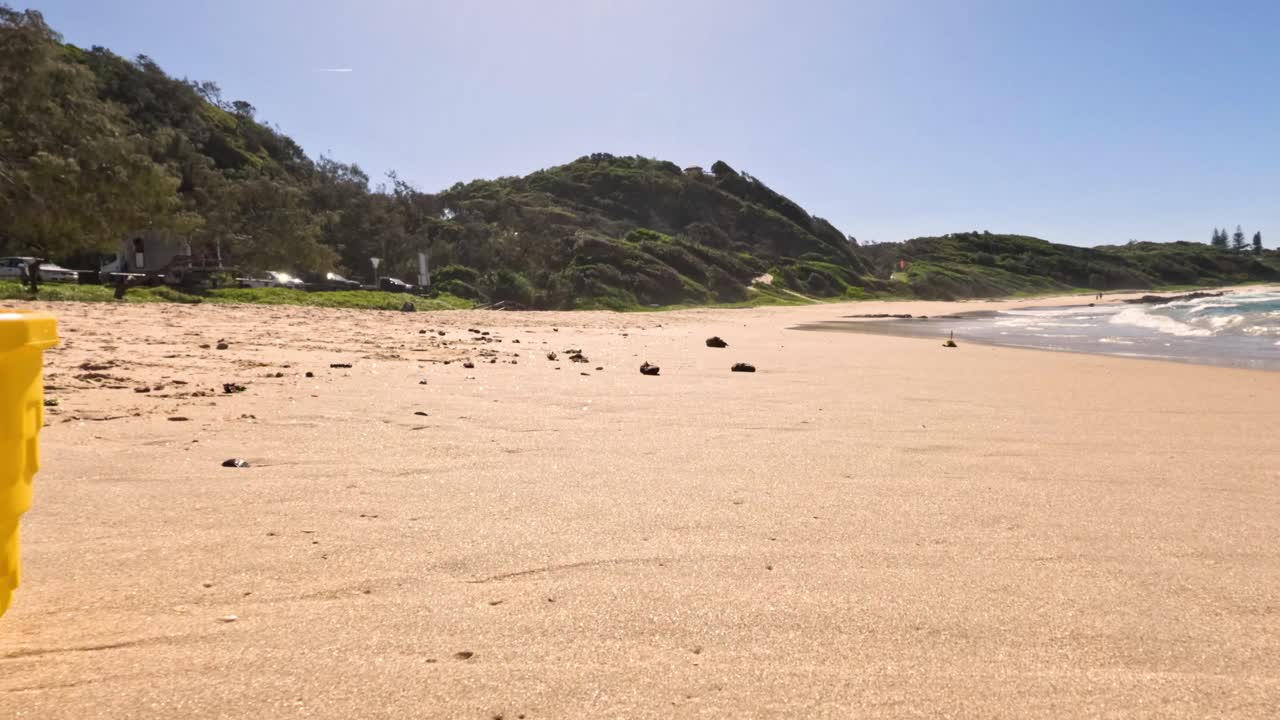el cubo amarillo se mueve a lo largo de la playa de arena