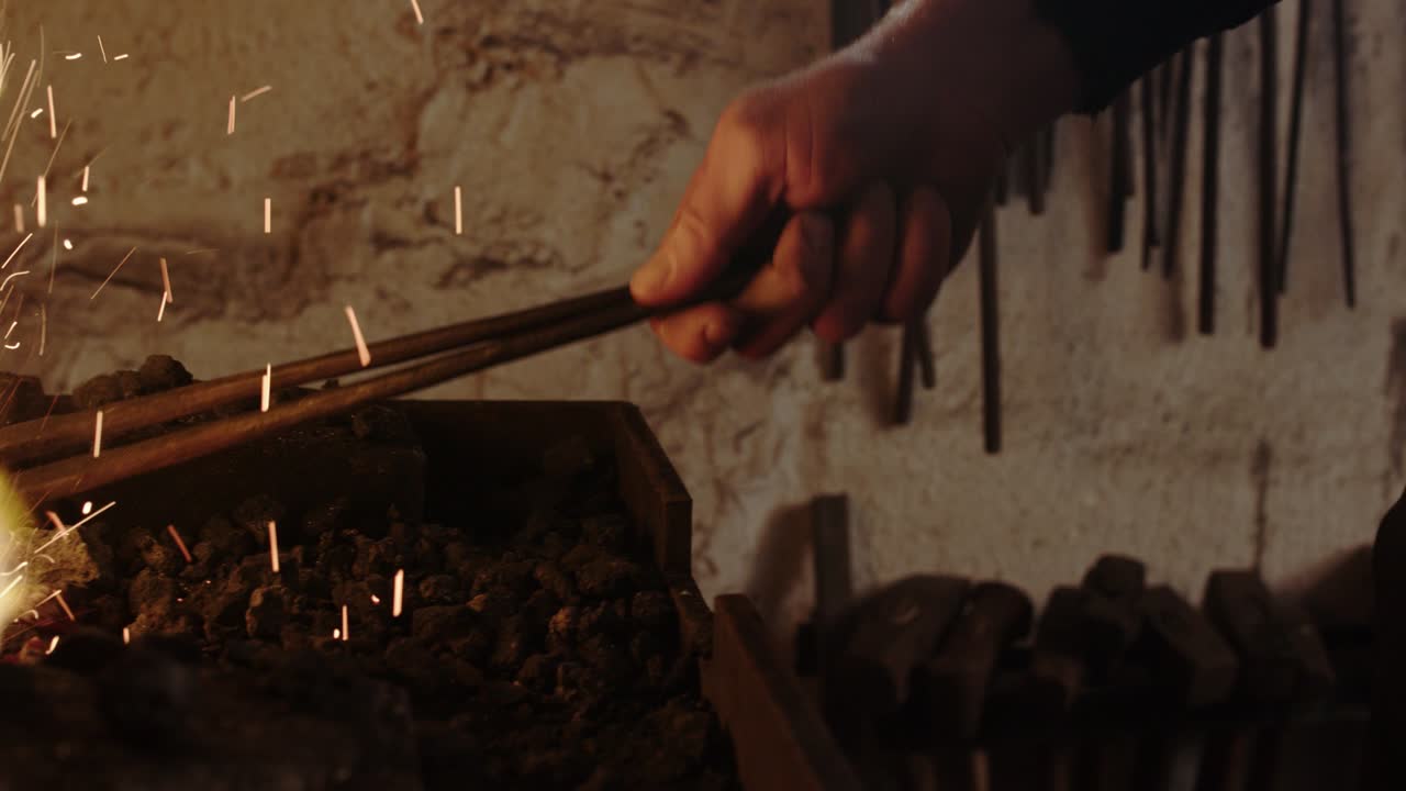 un herrero calentando hierro en su forja