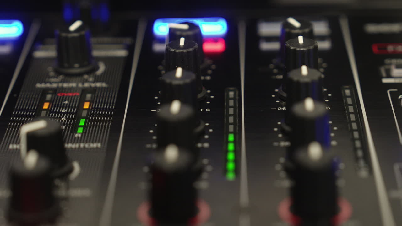 Primo piano del misuratore di un canale del mixer di un DJ che mostra livelli audio puliti e bilanciati in un club o in un ambiente di studio con apparecchiature professionali