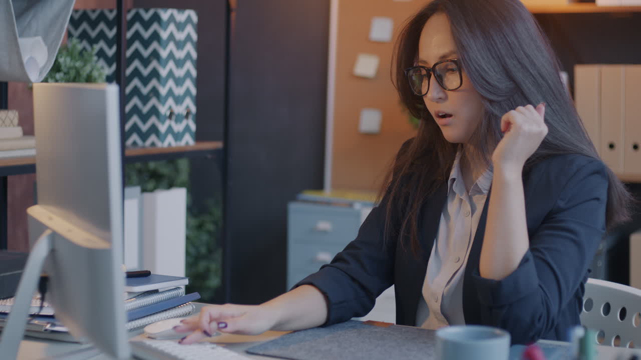 mujer trabajando en computadora en una oficina moderna