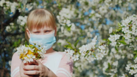 un niño triste con una máscara está admirando los problemas de alergia de un árbol en flor