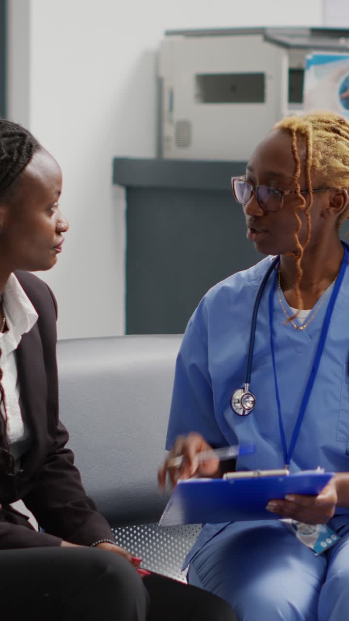 Vertical video: Medical nurse doing consultation with patient in waiting area