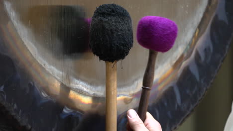 Two-Mallets-Striking-a-Gong-During-a-Sound-Bath-in-the-Sacred-Valley,-Cuzco-Region,-Peru---Close-Up