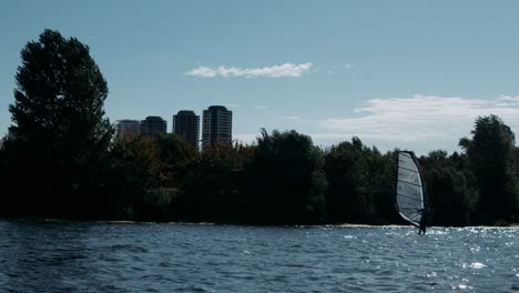 surfer windsurfing on river in slow motion. water sport at summertime