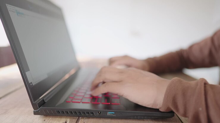 Nahaufnahme: Geschäftsmann tippt Informationen auf Laptop für Online-Shopping zu Hause ein.