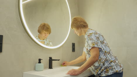 woman cleaning bathroom sink