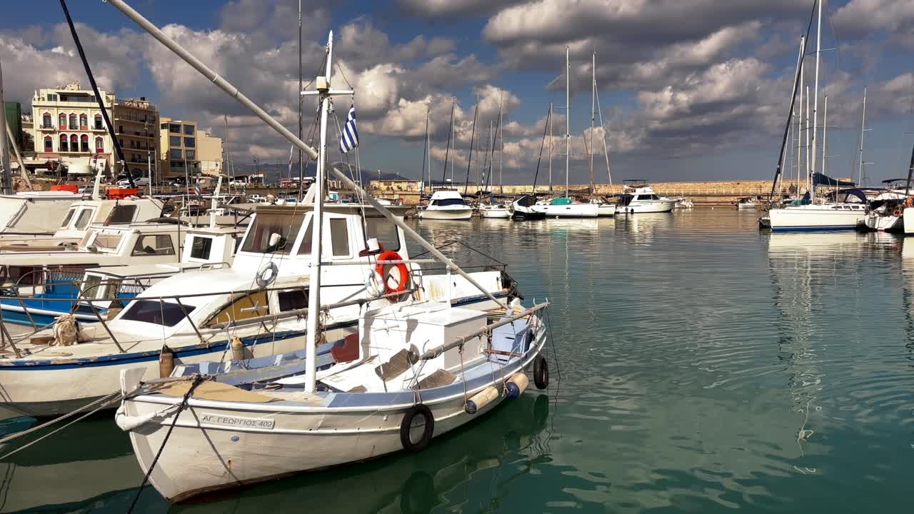 Boats docked at the marina in Heraklion, Crete, Greece under a cloudy sky
