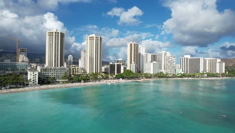 a drone glides over the ocean towards the beach revealing luxury ocean front hotels