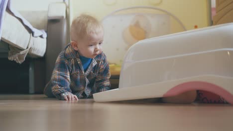 little boy crawls and elder sister hides under basin at bed