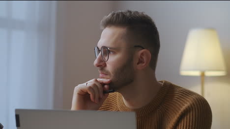 Der-Mann-Arbeitet-Zu-Hause-An-Einem-Projekt,-Freiberuflich-Und-In-Teilzeit,-Sitzt-Vor-Dem-Notebook-Im-Zimmer,-Nahaufnahme,-Porträt-Einer-Nachdenklichen-Person