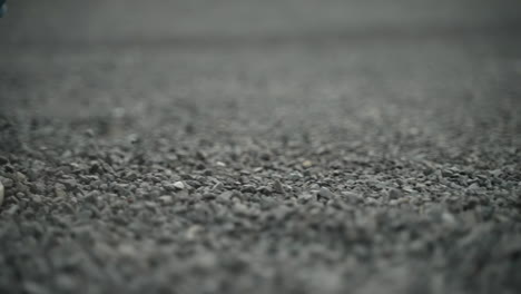 woman's shoes walking through small stones in super slow motion