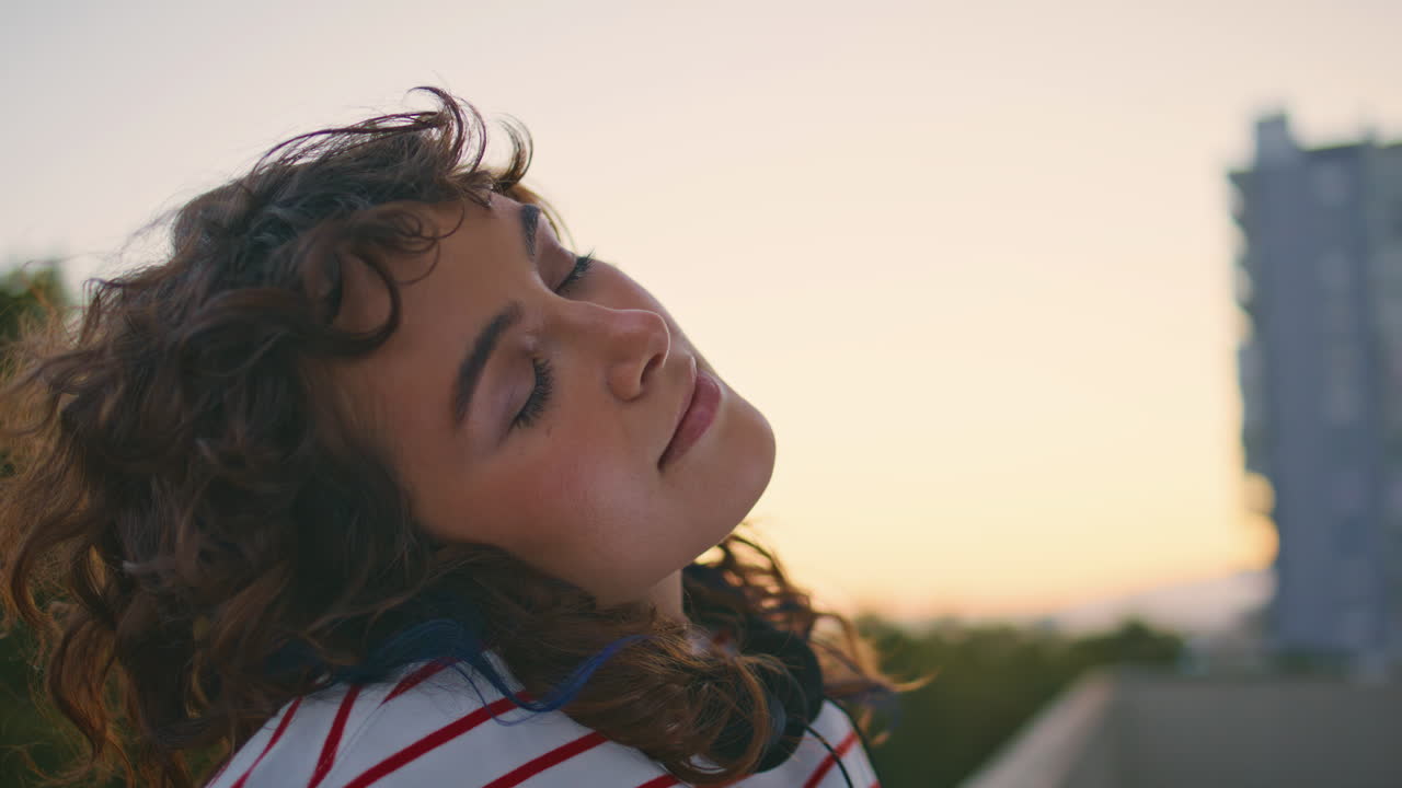 dama tranquila relajándose por la noche en el techo del edificio de cerca. mujer cerrando los ojos