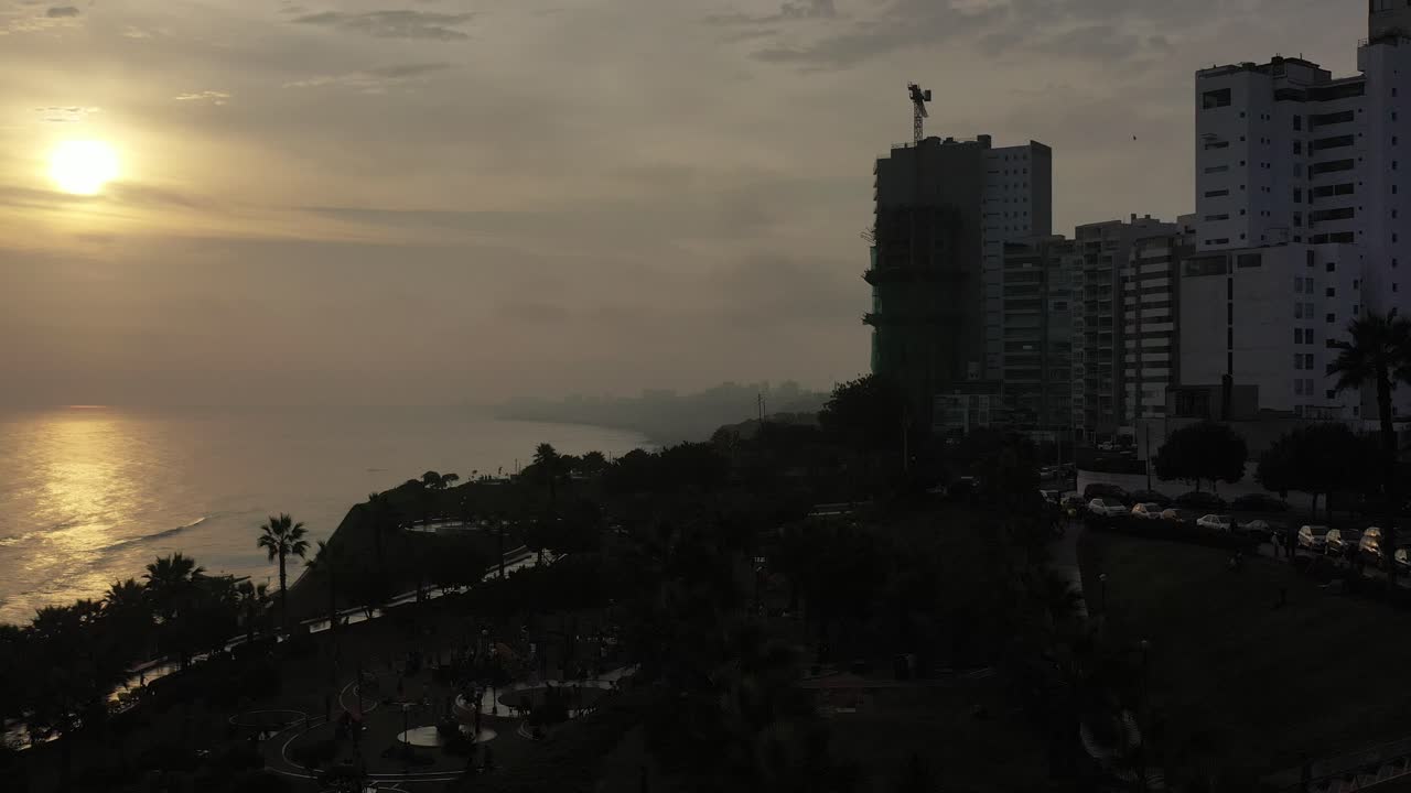 toma aérea de la puesta de sol tomada desde la costa verde en la ciudad de lima, ubicada en perú
