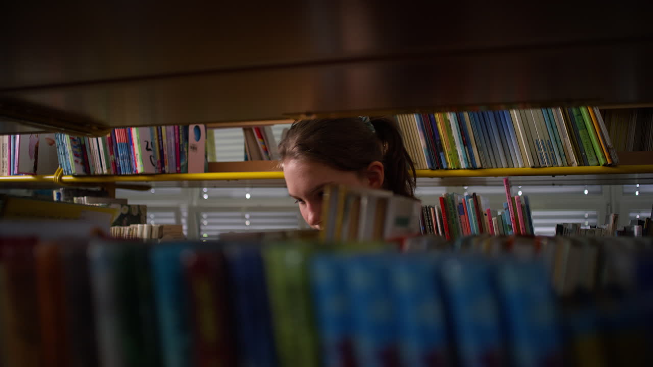 estudiante caminando en la biblioteca en busca de un libro, cerca de disparo de seguimiento