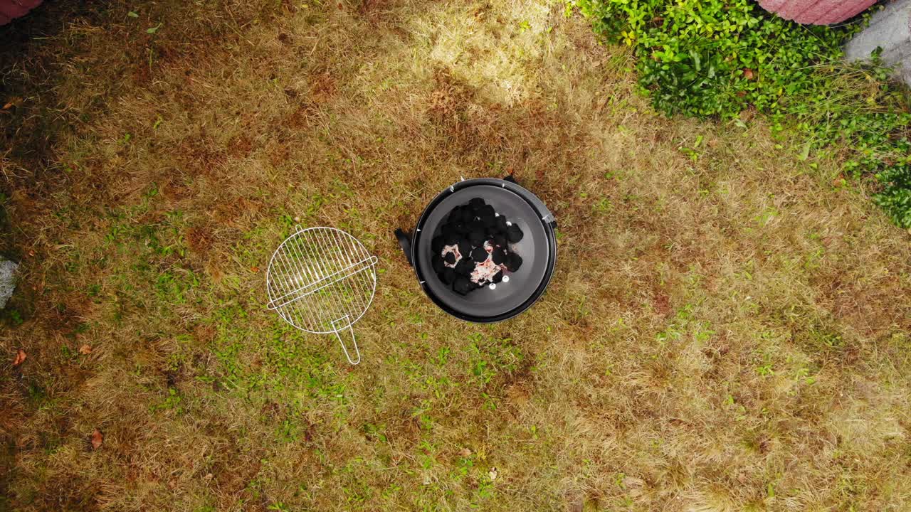 요리를 위해 야외에서 준비한 불을 밝힌 숯이 있는 둥근 바비큐 그릴의 최고 전망