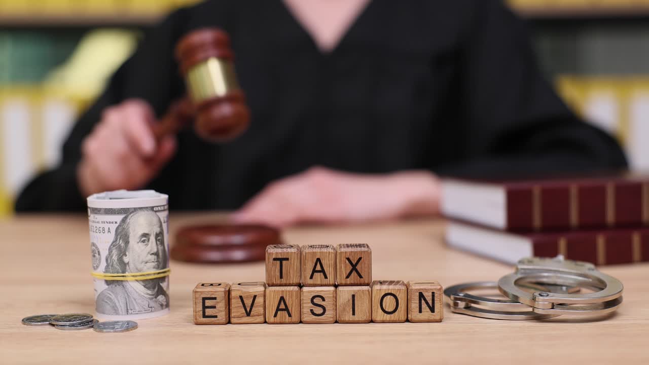 Concetto di evasione fiscale con denaro, manette e martelletto