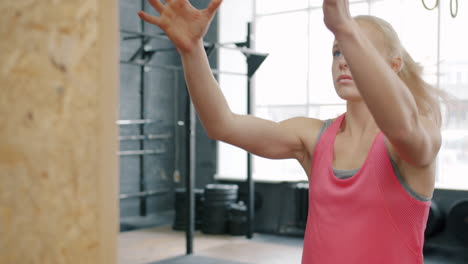 woman doing medicine ball exercise in gym