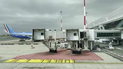 airport jet bridge and airplane at terminal on overcast day