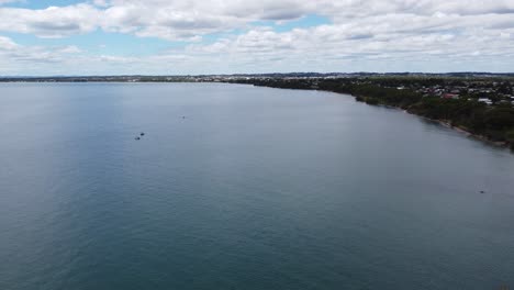 aerial view of a beautiful coast line with fishing boats on the water