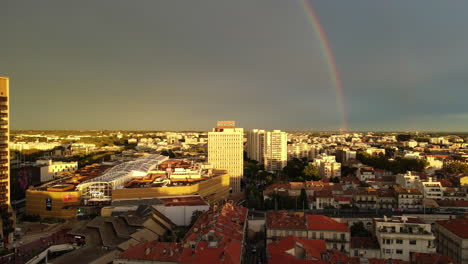 a breathtaking aerial view of montpellier illuminated by a vivid rainbow.