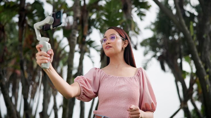 Donna che fa vlogging all'aperto con uno stabilizzatore per smartphone