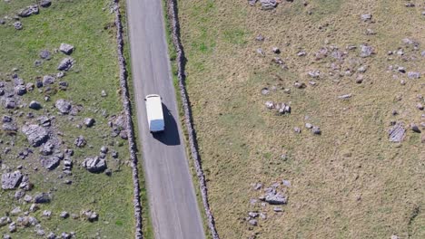 a delivery van drives on a winding road through the rocky landscape of the burren, county clare, ireland