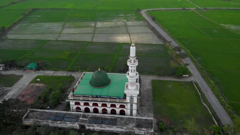 mezquita islámica de 4k en la tierra de hierba verde, tiro aéreo de avión no tripulado volando por encima del techo, cielo azul de día