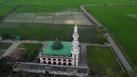 4k islam mosque on the green grass land, drone aerial shot flying above the roof, daytime blue sky