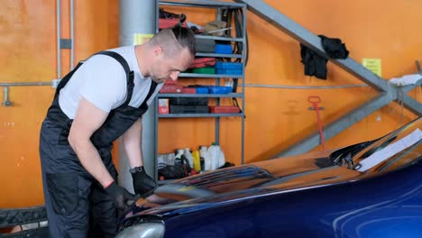 mechanic working on car engine in auto service garage