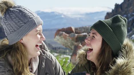 zwei junge frauen amüsieren sich auf einem verschneiten berg