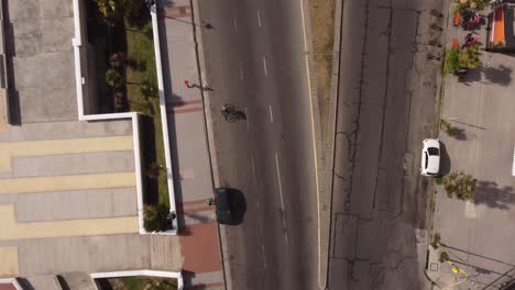 Top-down-ansicht-Eines-Mannes,-Der-An-Einem-Sonnigen-Tag-In-Einem-Natürlichen-Hintergrund-Neben-Der-Straße-Von-Fahrzeugen-Auf-Der-Straße-Von-Mar-Del-Plata-In-Argentinien-Läuft