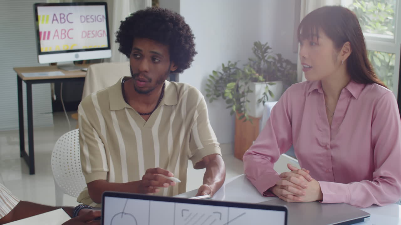 Multicultural Colleagues Discussing Ideas about App Developing at Office