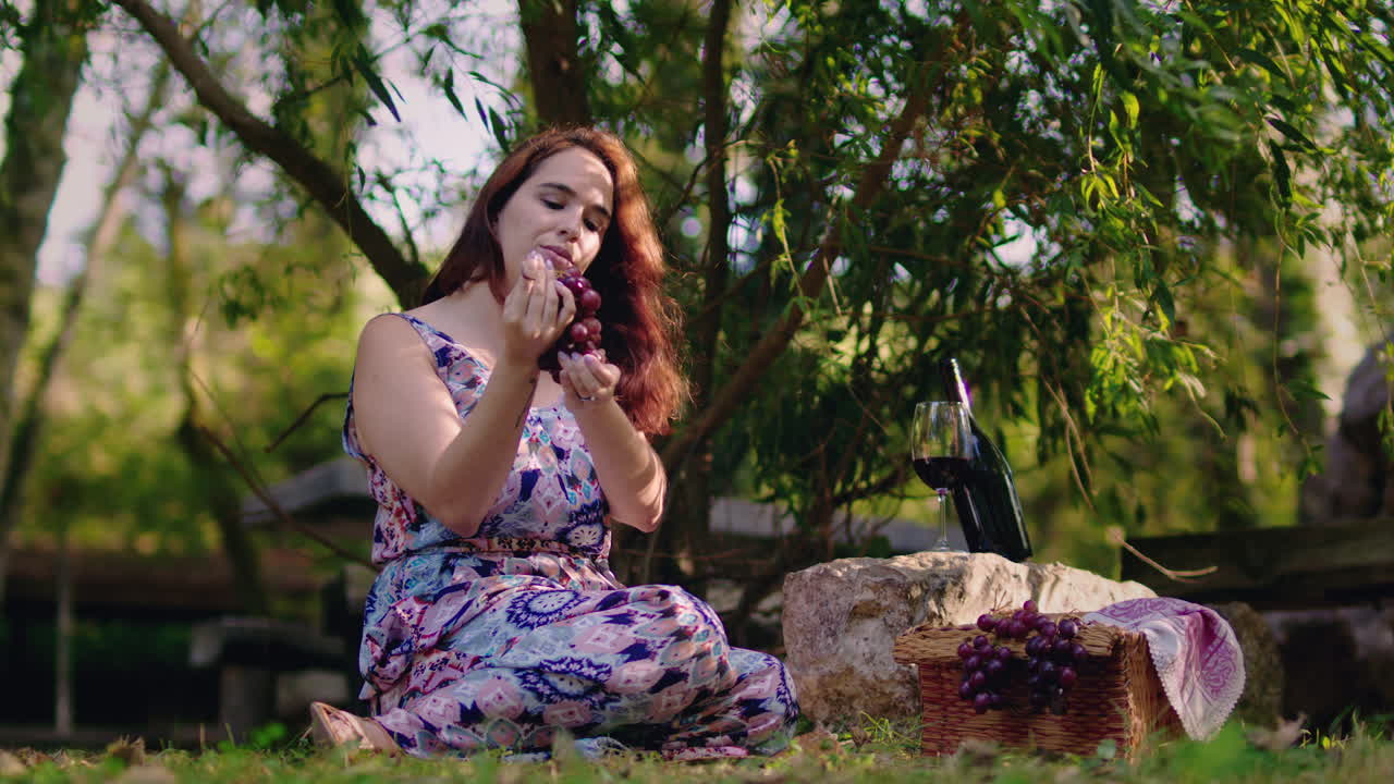 la chica recoge una uva de un racimo y se la come a cámara lenta.