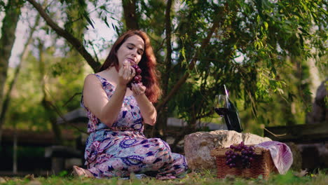 la chica recoge una uva de un racimo y se la come a cámara lenta.