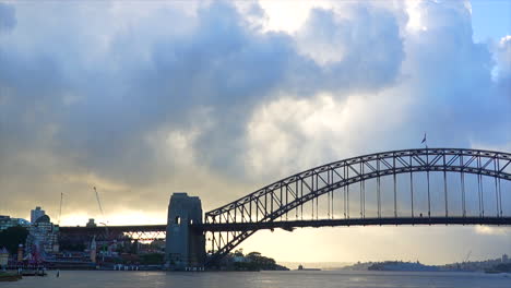 The-sun-rises-behind-white-clouds-in-Sydney-Harbour,-Australia