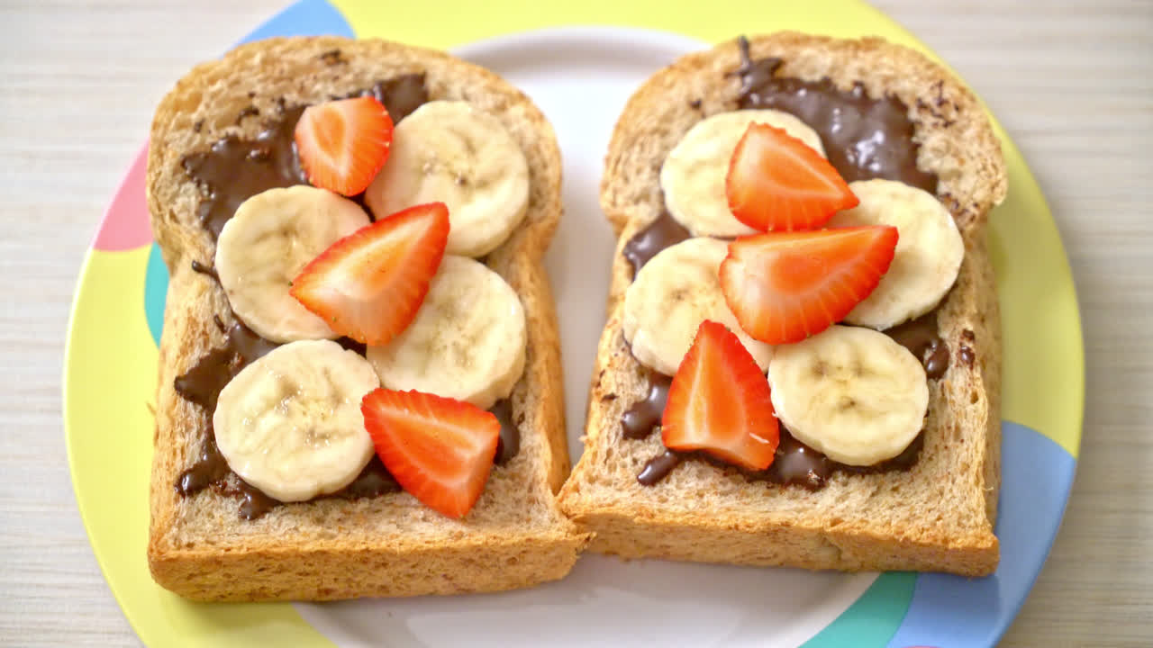 pan integral tostado con plátano fresco, fresa y chocolate para el desayuno