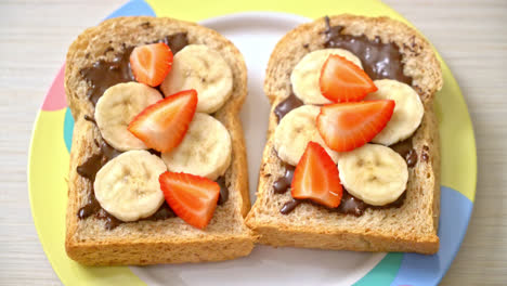 whole wheat bread toasted with fresh banana, strawberry and chocolate for breakfast