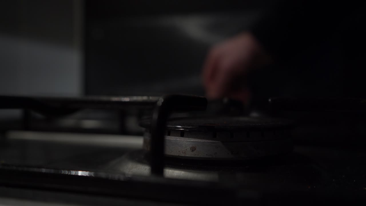 defocused 배경 손은 가스 쿡탑 버너에 푸른 불꽃을 발화