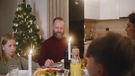 pareja y sus hijos rezan y bendicen la mesa antes de la cena familiar de navidad 2