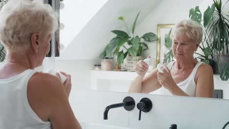 Senior-caucasian-woman-applying-antiperspirant