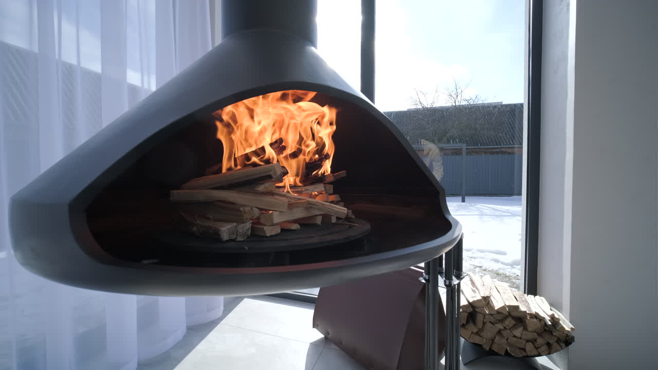 Moderne hængende pejs med brændende flammer og sneklædt udsigt
