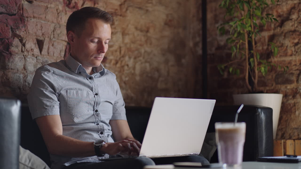 hermoso desarrollador masculino o estudiante trabajando estudiando con computadora portátil en una cafetería. trabajo remoto independiente educación en línea autónomo