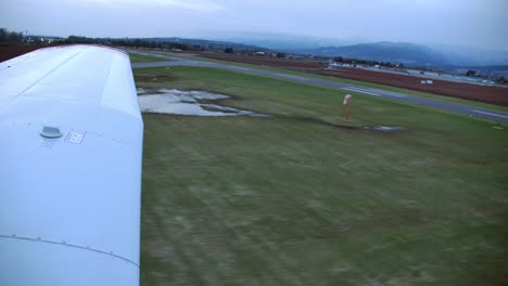 vista estática del ala de un avión ligero al aterrizar en la pista al anochecer