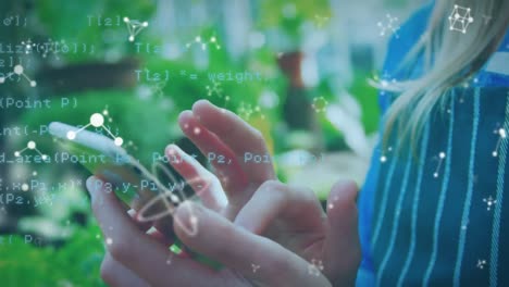 animación de procesamiento de datos y moléculas sobre las manos de una mujer caucásica usando un teléfono inteligente