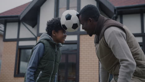father and son playing soccer