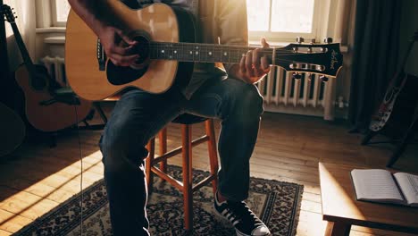 Warm, intimate video scene of a person playing guitar in a sunlit room