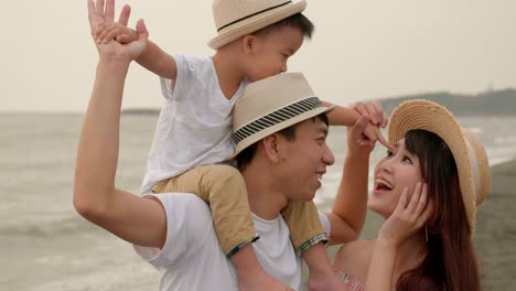 happy asian family having fun on the beach