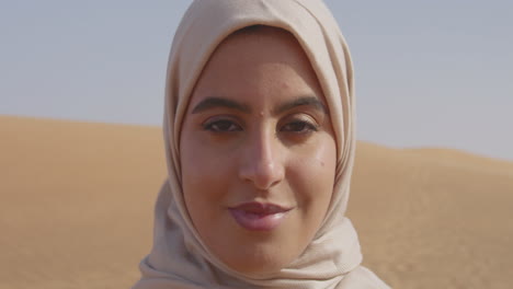 Close-Up-Portrait-Of-A-Beautiful-Muslim-Woman-In-Hijab-Standing-In-A-Windy-Desert-And-Looking-At-Camera-1