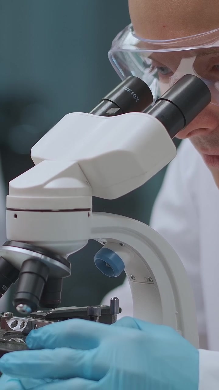 Close-up of Scientist Examining Sample with Microscope