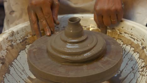 potter making a earthen pot on a pottery wheel